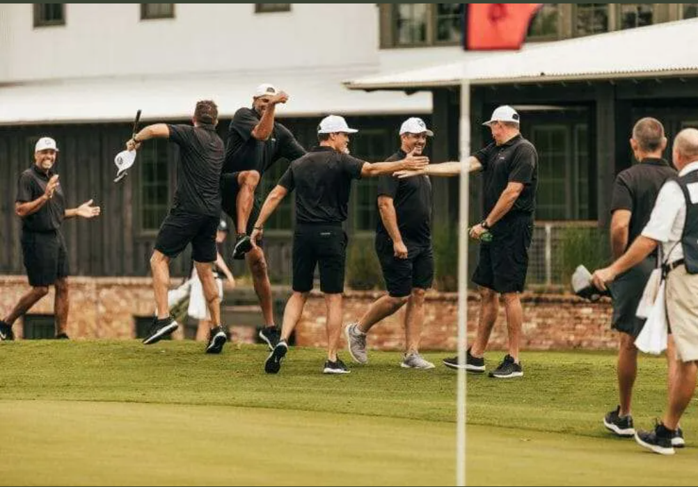 Golfers celebrating together beside the green