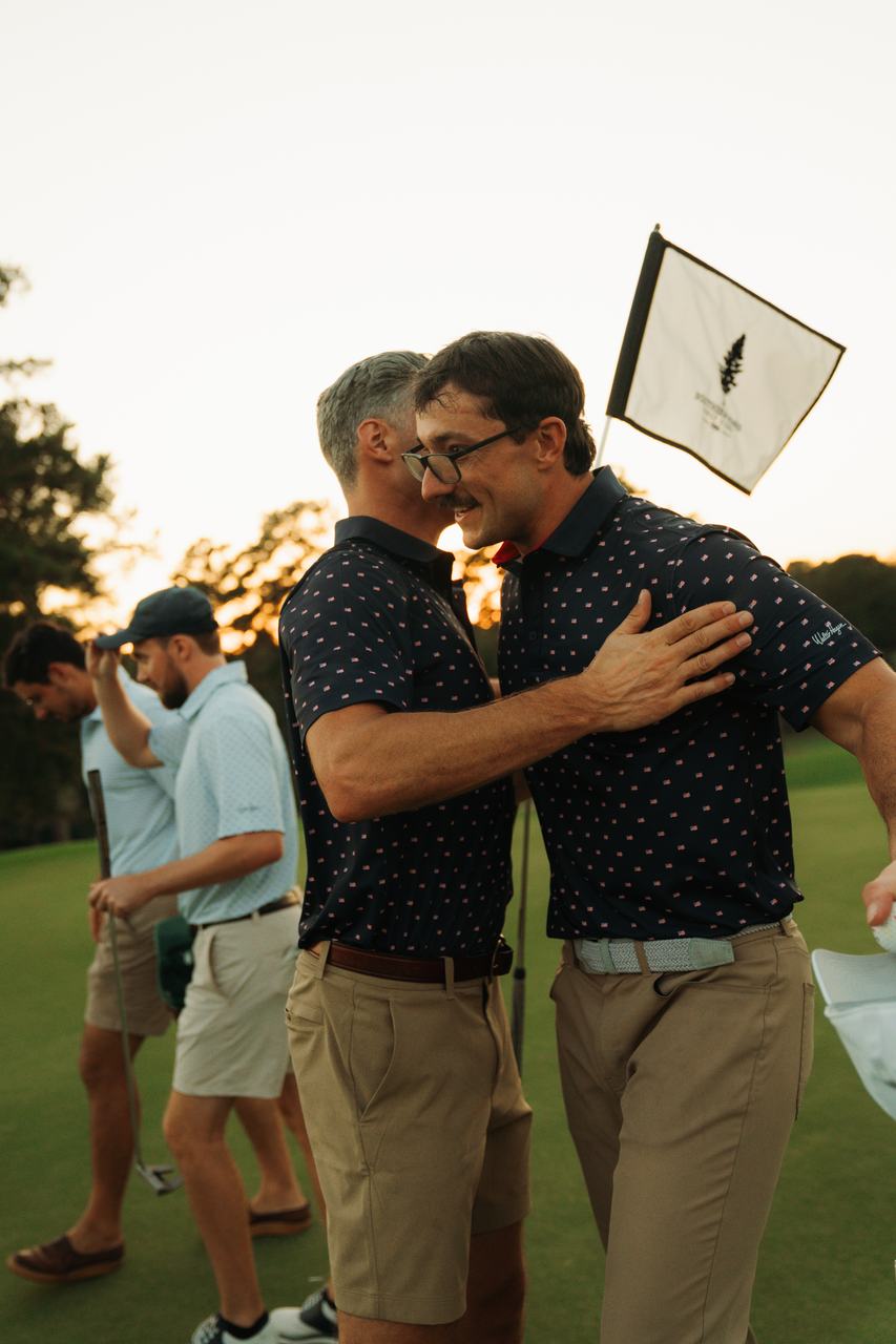 Two players embrace on the green at Southern Pines at sunset
